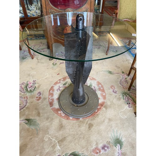 41 - An occasional table with circular glass top, the base made from a Zeppelin bomb - 30in. dia.