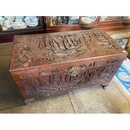 34 - A Chinese carved camphorwood chest, on short cabriole legs - 40in. wide