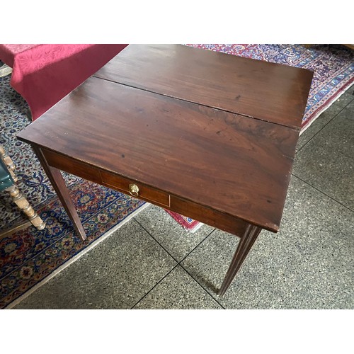 82 - A Georgian mahogany tea table with rectangular folding top, frieze drawer with brass lion mask ring ... 