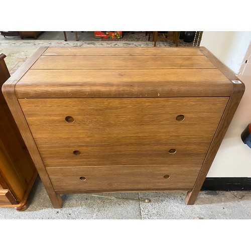 36 - An oak chest with rounded front, fitted three wide drawers, on square legs - 35in. wide