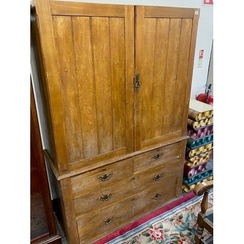 17 - An Edwardian oak linen press, the upper part fitted two panelled doors enclosing three sliding trays... 