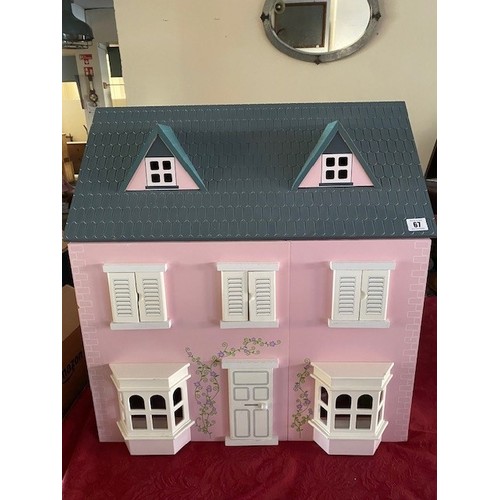 67 - A child's modern wooden dolls house, pink painted, complete with a selection of furniture and figure... 