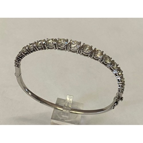 249 - A platinum stiff hinged bangle set with seventeen graduated round brilliant cut diamonds to the top