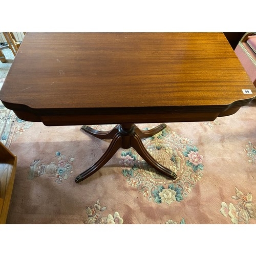 50 - A mahogany tea table with shaped rectangular top, urn form centre column, four reeded downswept legs... 