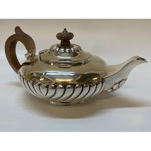 223 - A George IV silver teapot of compressed spherical form with half gadroon decoration, wooden handle a... 