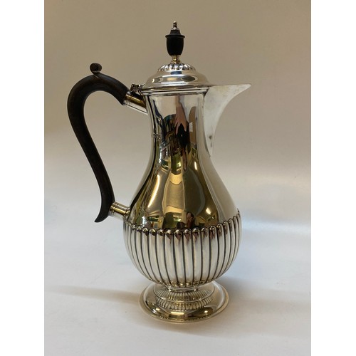 224 - A silver hot water jug with half gadroon decoration, ebonised knop and handle, on circular foot - Sh... 