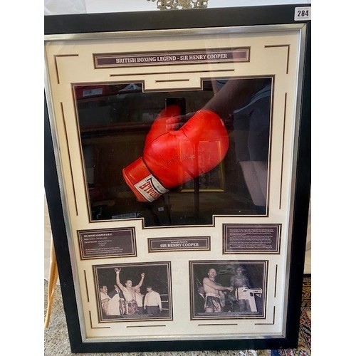 284 - A Lonsdale boxing glove signed by Henry Cooper with two black and white images and brief resume of h... 