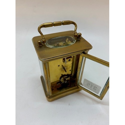 315 - A carriage clock with white enamel dial, repeating movement, in a brass and glass panelled case with... 