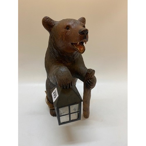 335 - A lamp in the form of a Black Forest bear holding a glass lantern and resting on a stick - 13 1/2in.... 