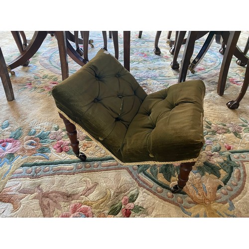 56 - A 19th Century gout stool upholstered in buttoned green velvet, on turned legs terminating in brown ... 