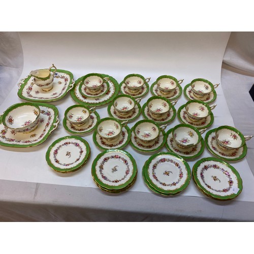 108 - A Coalport tea service with apple green borders and decorated flowers comprising:- twelve cups, twel... 