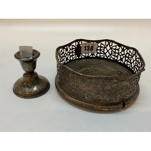 130 - A silver coloured metal bottle coaster with saw pierced decoration and a silver desk candlestick