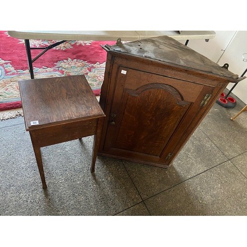 95 - A Georgian oak wall hanging angle cabinet with panelled door and an oak sewing table with hinged lid... 