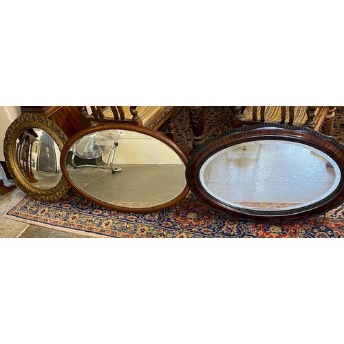 96 - An Edwardian oval bevelled wall mirror in a mahogany and inlaid frame - 21in. x 31in., an oval bevel... 