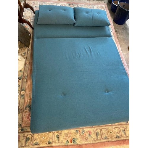 86 - A modern futon upholstered in blue material, two loose cushions, on turned legs - 47in. wide