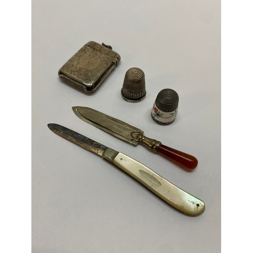 179 - Two silver thimbles, a fruit knife with silver blade and mother of pearl handle, a silver vesta case... 