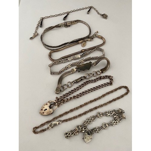 301 - Seven silver bracelets, two with heart shaped padlocks, snake link bracelets, etc.