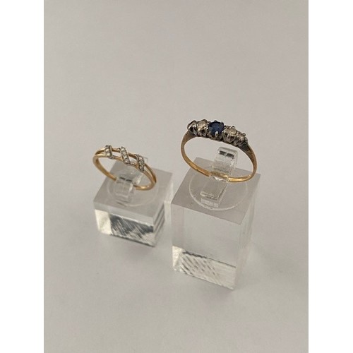 303 - A lady's ring set centre sapphire flanked to each side by two diamonds, on an 18ct. gold shank and o... 