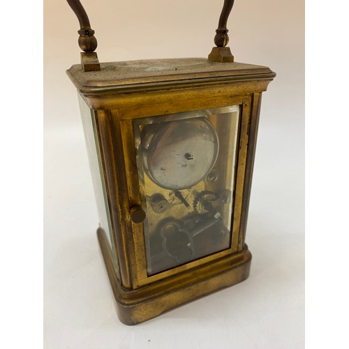 331 - A carriage clock, white enamel dial, seconds dial, striking movement on a bell, in a brass and glass... 