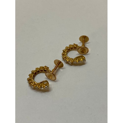 310 - A pair of 18ct. gold and diamond set hoop earrings with screw backs