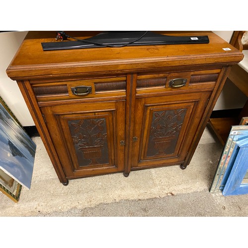 43 - An Edwardian walnut sidecabinet fitted frieze drawer above two carved panelled doors to urns of flow... 