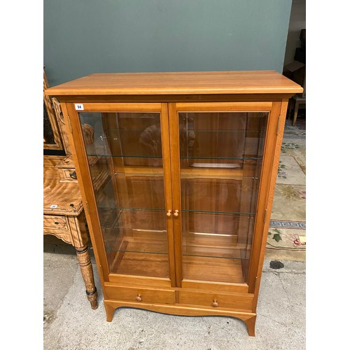 54 - A modern cherrywood display cabinet fitted two glass doors, two drawers under, turned wood knob hand... 