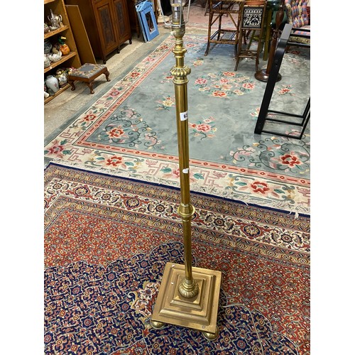 62 - A brass standard lamp with turned column, on stepped square base and pill feet