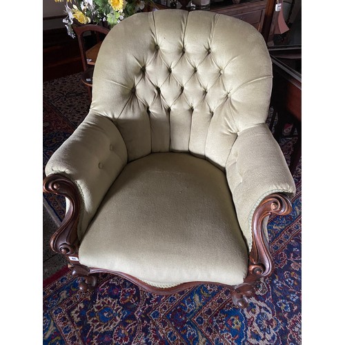 92 - A Victorian mahogany framed armchair upholstered in green buttoned material, on short cabriole legs