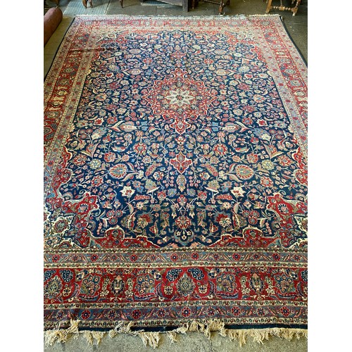 3 - A large Eastern carpet, cream, red and blue field with floral decorated centre, floral pattern borde... 