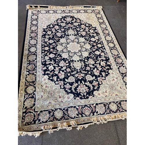 17 - A Beluchi manmade silk rug, black field with cream and red floral decoration and border, fringed  - ... 