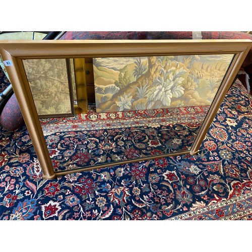 83 - A rectangular overmantel mirror in a gold sprayed frame - 36in. x 48in.