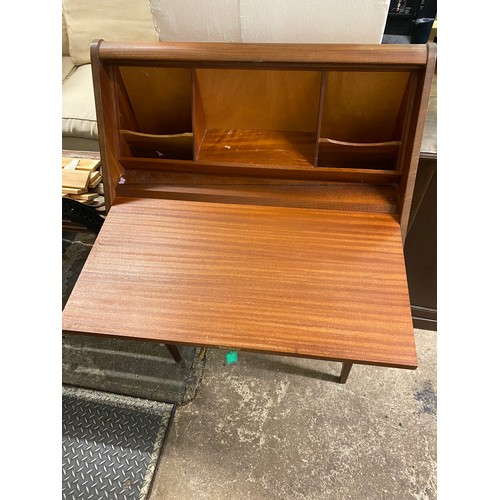 66 - A 1960's teak bureau with hinged sloping front enclosing fitted interior above frieze drawer, on squ... 