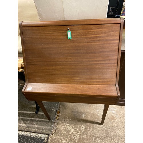 66 - A 1960's teak bureau with hinged sloping front enclosing fitted interior above frieze drawer, on squ... 