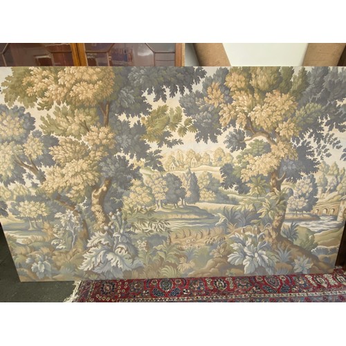 54 - A large machine made wall hanging tapestry depicting a wooded landscape with river and bridge - 69in... 