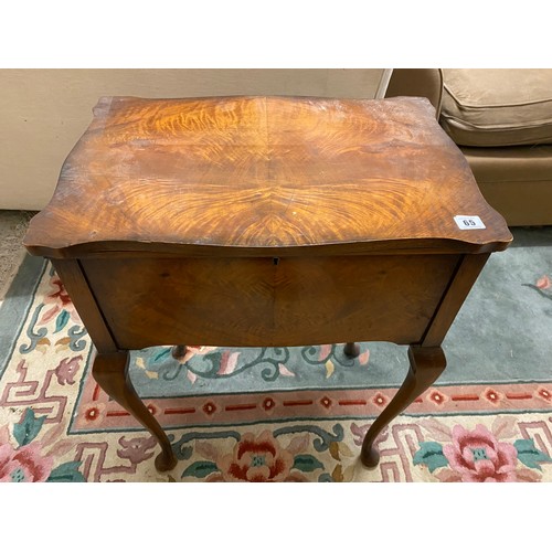 65 - A walnut veneered sewing table with hinged lid on slender cabriole legs - 21in. wide