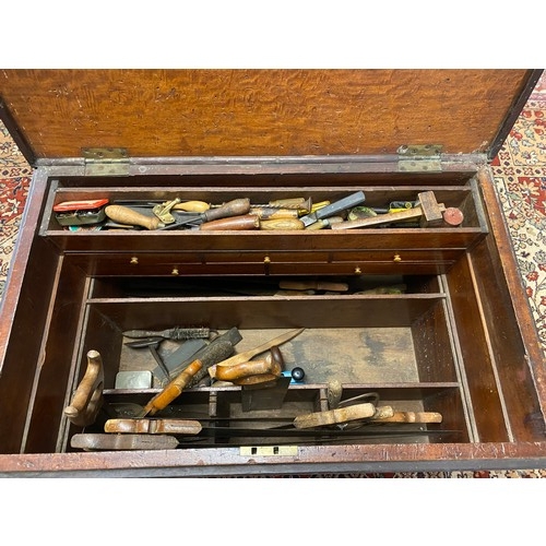 51 - A mahogany carpenters chest with rope carrying handles, fitted with a selection of hand tools includ... 