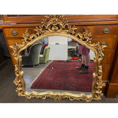 58 - A modern wall mirror in a shaped frame with flower and leaf scroll decoration  - 45in. x 45in.