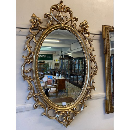 76 - An oval wall mirror in a gilt scroll frame - 36in. x 23in. and a small rectangular wall mirror in a ... 