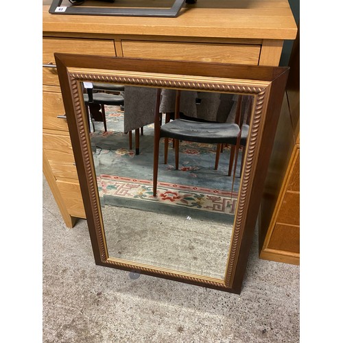 79 - A modern wall mirror in a mahogany frame - 25in. x 36in. and an oak veneered chest fitted five drawe... 