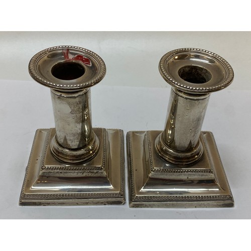202 - A pair of plain silver desk candlesticks with beaded decoration, stepped bases - Sheffield 1933, mak... 