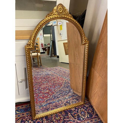 157 - A large modern shaped bevelled wall mirror in a gilt frame with flower head and leaf pediment, ropet... 