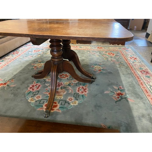 61 - A Georgian mahogany dining table with rectangular top, two extra centre leaves, on twin pillar suppo... 