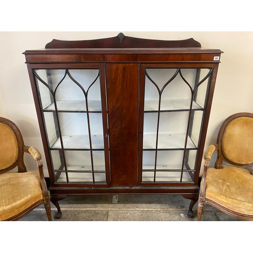 59 - A mahogany display cabinet with low raised back,  fitted two glass doors enclosing shelves, on cabri... 