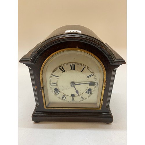 114 - An Edwardian mantel clock with silvered dial, striking on a gong, in a mahogany finished case with d... 