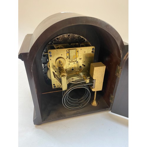 114 - An Edwardian mantel clock with silvered dial, striking on a gong, in a mahogany finished case with d... 