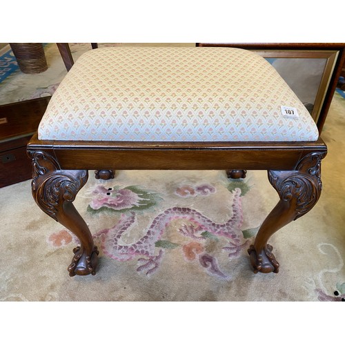 107 - A dressing stool on a walnut finished frame, the cabriole legs with leaf scroll knees and claw and b... 