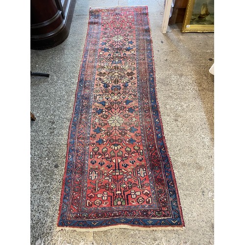 6 - A Persian runner, red and blue field with floral decoration, fringed - 30in. x 100in.