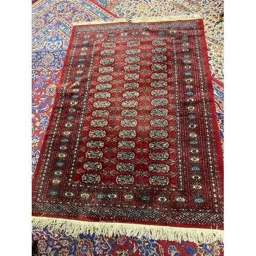 10 - A Bokhara rug, red field with forty five medallions to the centre, fringed - 50in. x 70in.