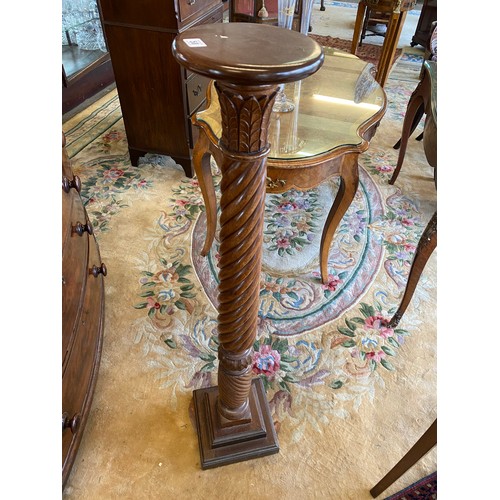 50 - A mahogany torchere with wrythen column and petal collar, on stepped square base