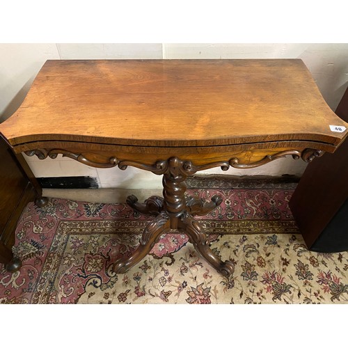 40 - A Victorian rosewood tea table with shaped rectangular folding top, the frieze with scroll decoratio... 